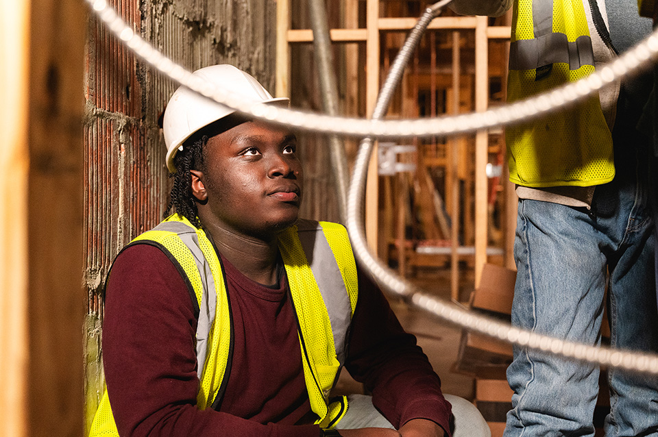 A construction worker wearing a hard hat and looking up