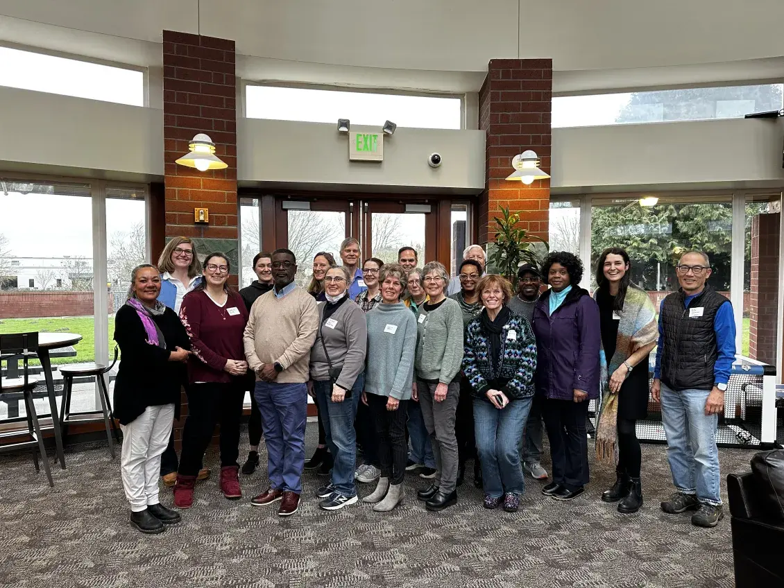 A group of people standing in front of a bay of windows