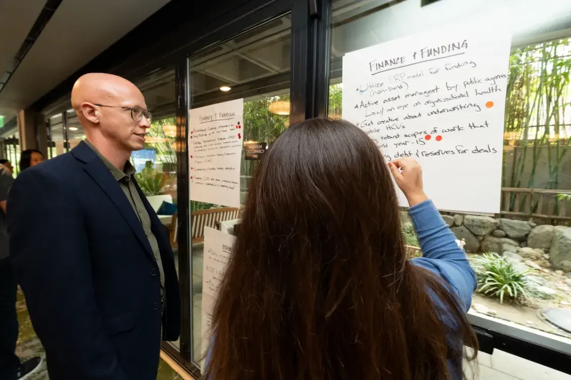 Man and woman looking at notes on large note paper