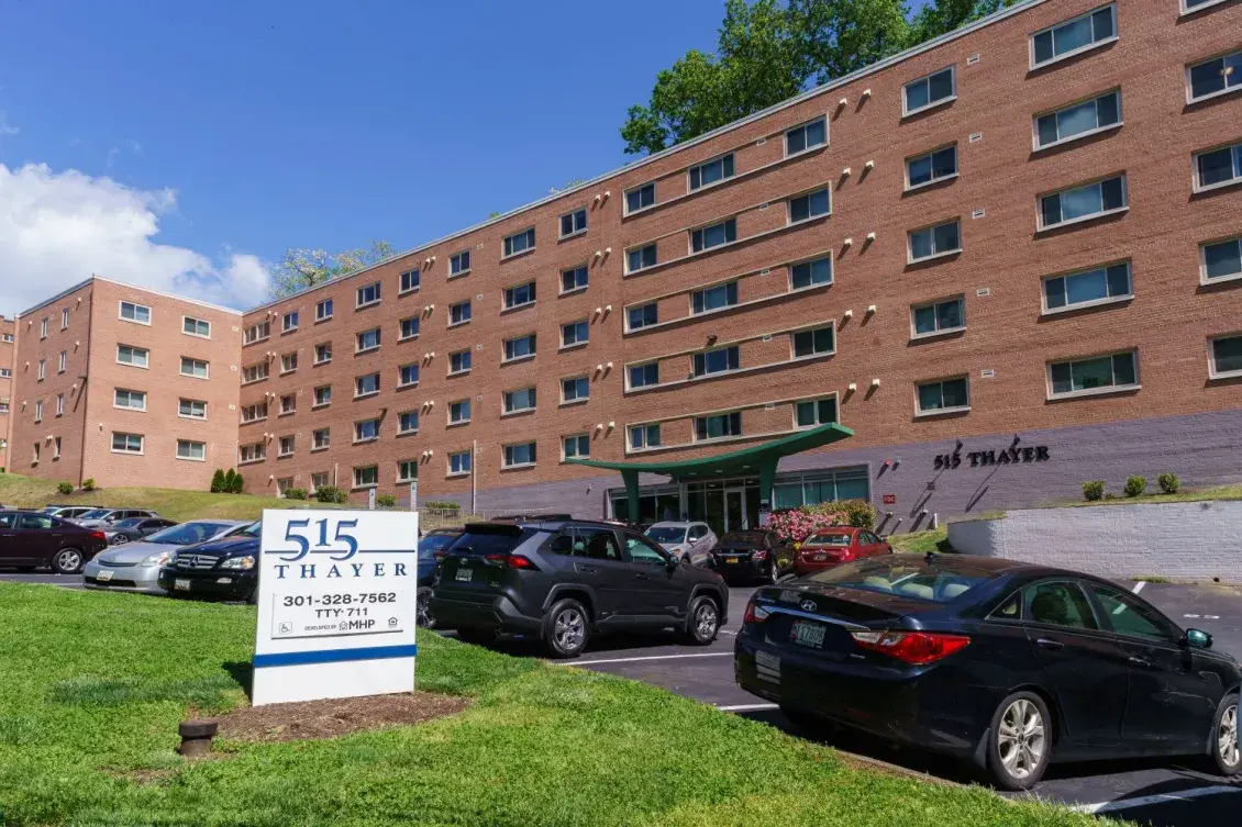 The exterior of a wide brick multifamily building, 515 Thayer, a preservation project.