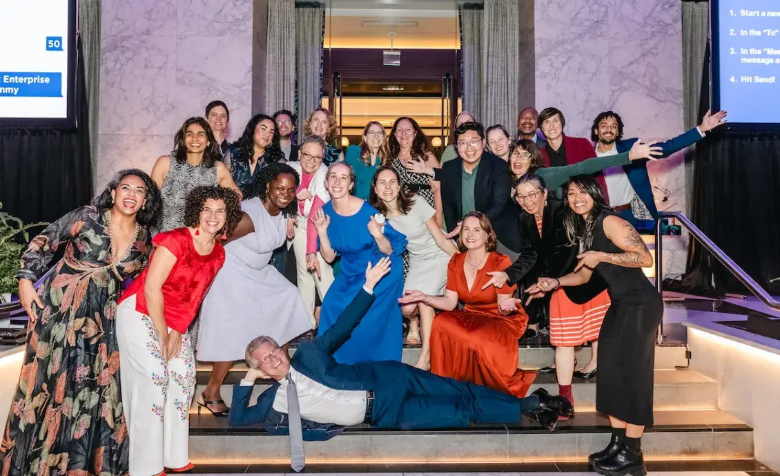 Smiling people in brightly colored, festive clothing playful posing for a group photo 