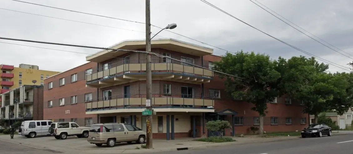 Brick two-story apartment building surrounded by cars