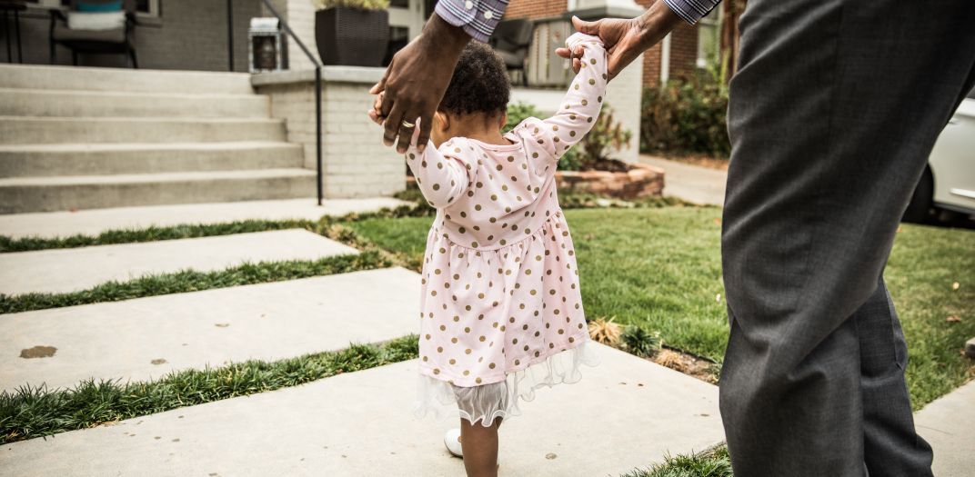 little girl walking with adult holding her hand