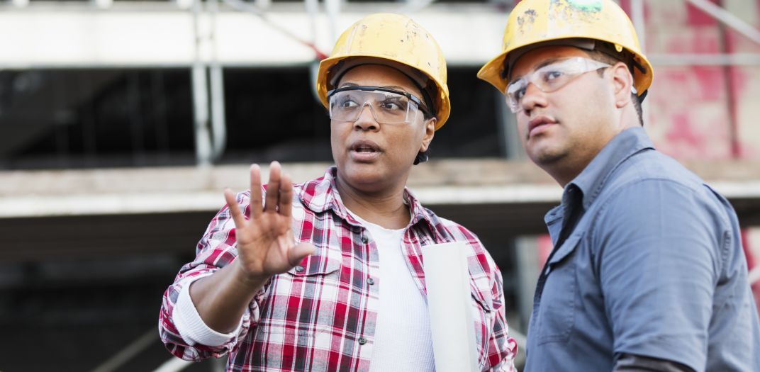 Two workers talking on a construction site