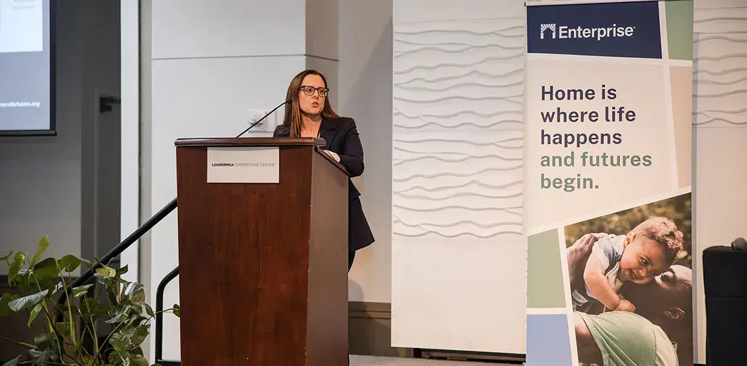 A woman standing at a podium presenting