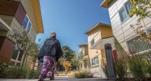 Woman walking on a sidewalk through a residential community