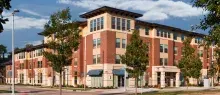 Brick multifamily building viewed from corner against a blue sky