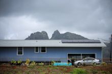 A low-slung building with mountains in the background