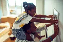Adult and child putting a photo on the wall