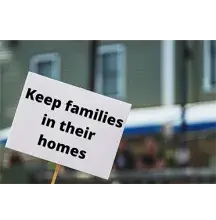 Sign with the words "Keep families in their homes" printed on it