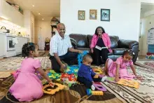 Family sitting in living room with children playing with toys