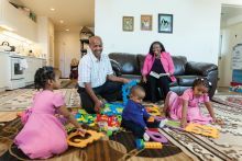 Family sitting in living room with children playing with toys