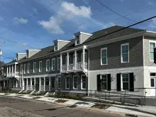 Corner view of the Grove Place Apartment buildings, two-story gray- and cream-colored buildings