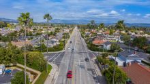 Aerial view of a busy intersection in California with palm trees, buildings, and hills in view