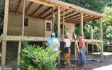 Three workers repairing a home damaged by a devastating flood in Eastern Kentucky
