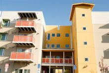 Apartment building with yellow, cream, and tan walls with terracotta color balconies