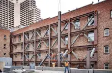 Men working on red brick and steel building