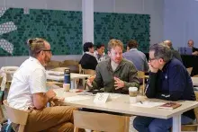 Three people sitting at table having a discussion
