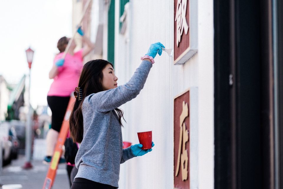 A woman painting a wall outside