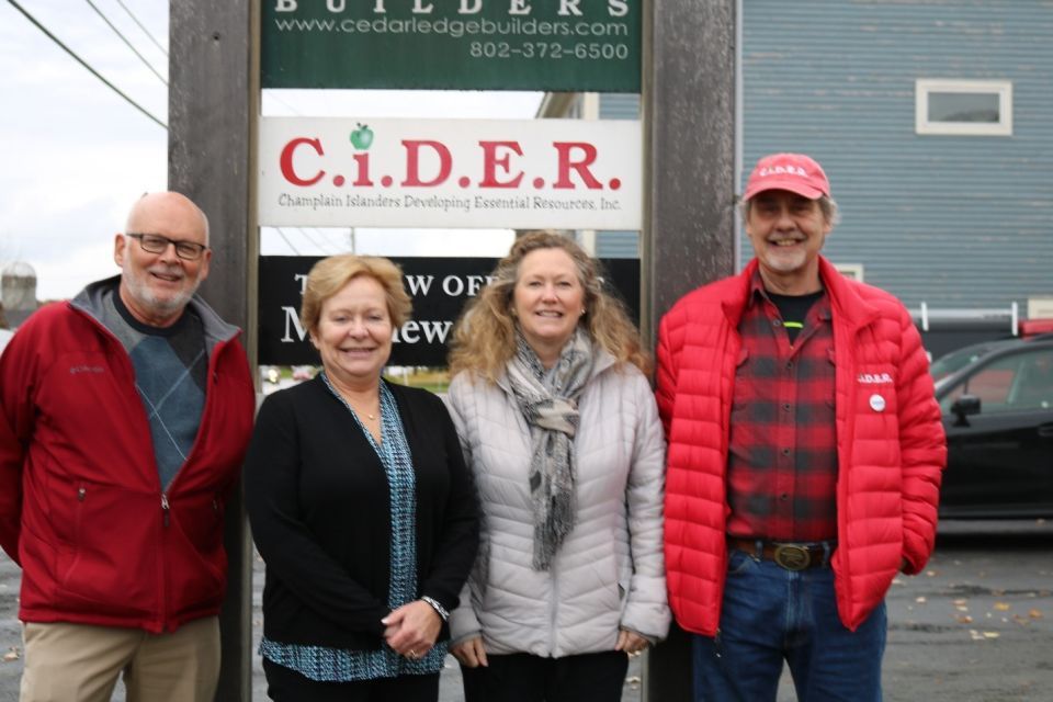 two men and two women who work with Champlain Islanders Developing Essential Resources in front of a C.I.D.E.R sign