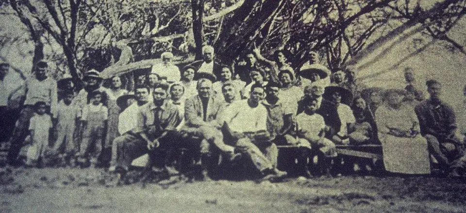 An older photo showing a large group of people seated and facing the camera