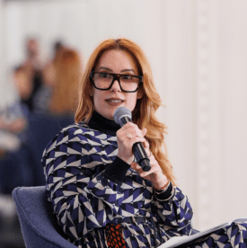 Romina Ruiz, USA Today White House Editor, a woman with red hair and glasses, holding a microphone