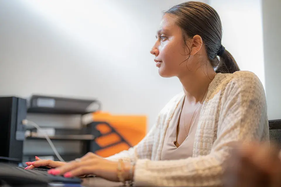 Woman sitting at a desk typing on a keyboard