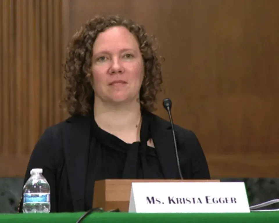 Woman seated at a table with a microphone