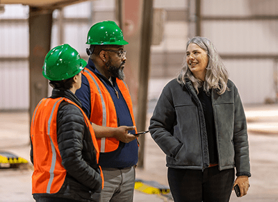 Three people talking at a construction site