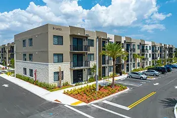 Rendering of a three-story apartment building and parking lot