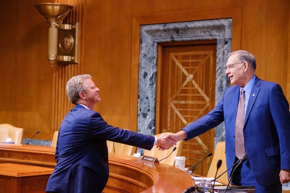 Shaun Donovan shaking hands after a Congressional testimony