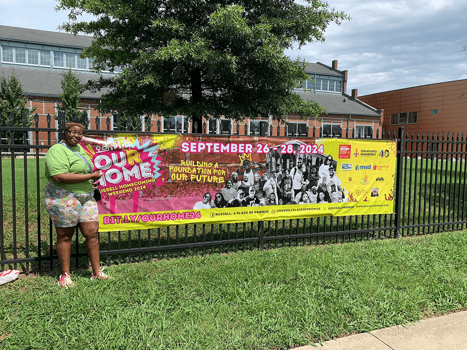 A person standing and holding a banner next to them