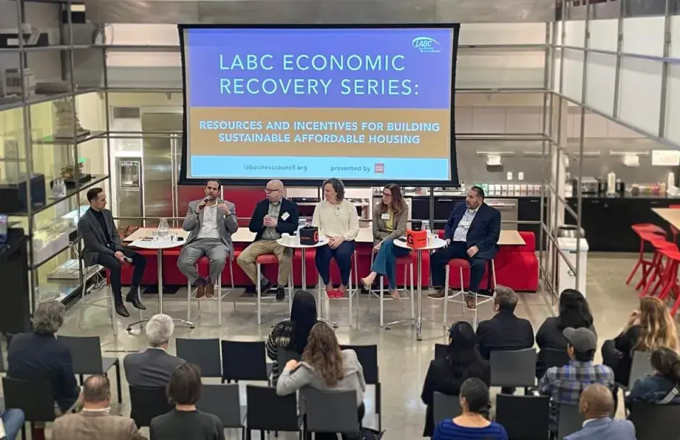 People sitting in high chairs in front of audience