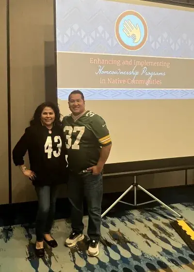 Woman and Man in football jerseys standing in front of PowerPoint Slide Screen