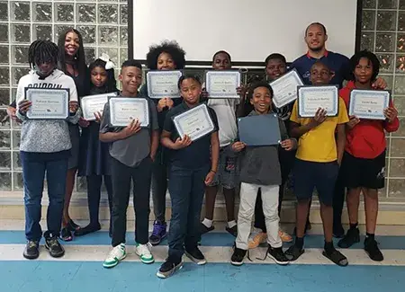 Ryan Brock with summer campers holding certificates