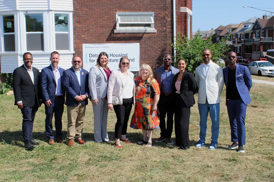 Group of people standing in front of a brick building