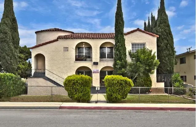 Multistory stucco building with red tile roof 
