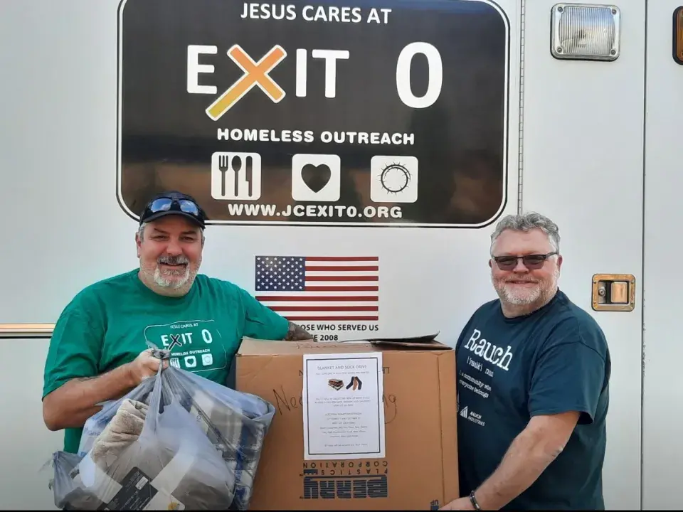 Two smiling men with a box and bags
