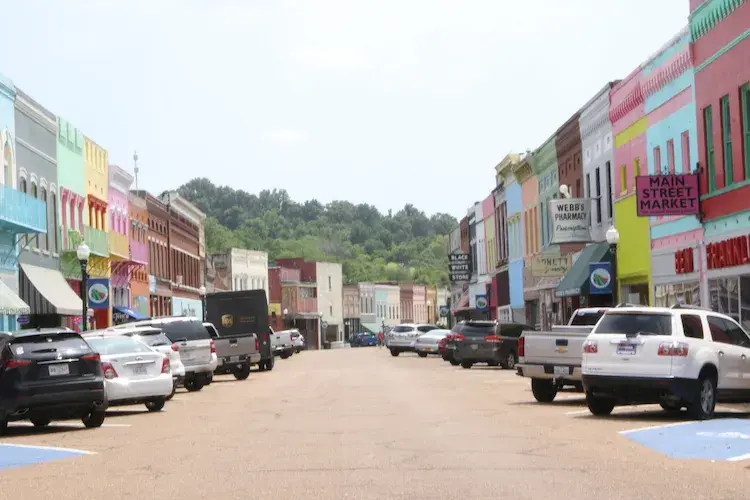 Cars and trucks parked in front of colorful buildings