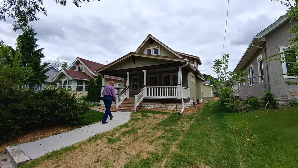 A person walking up to a house