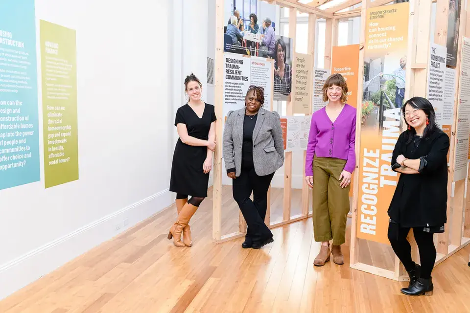 Four woman standing in front of an exhibit and smiling for a picture