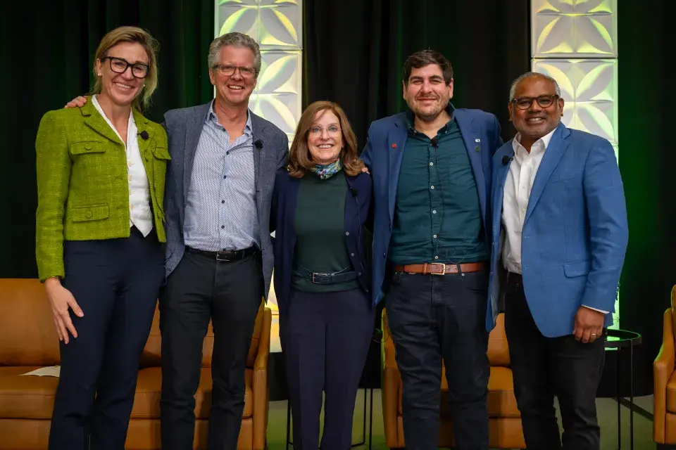 Group of five people stand smiling 