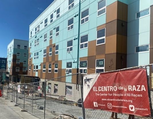 Teal and reddish brown apartment building under construction