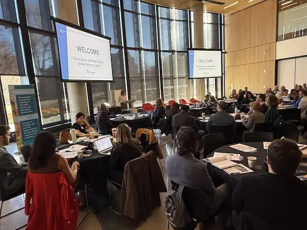 Meeting room filled with people looking toward the speaker in the front
