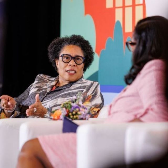U.S. Department of Housing and Urban Development Secretary Marcia Fudge sitting and speaking with another woman