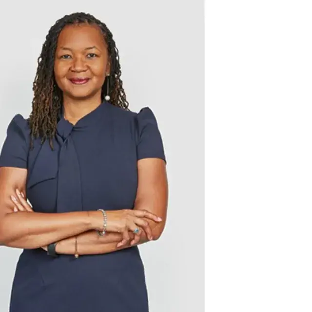 Woman stands with arms crossed 