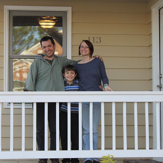 A family standing on the porch of their home