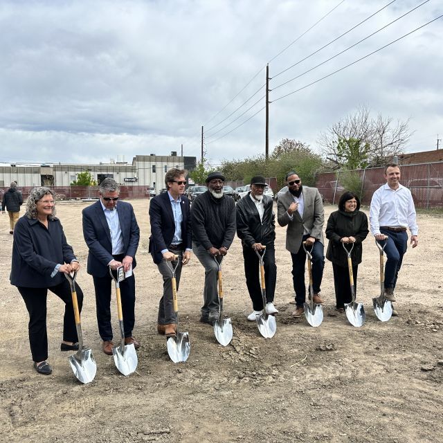 Eight people with shovels at housing groundbreaking.