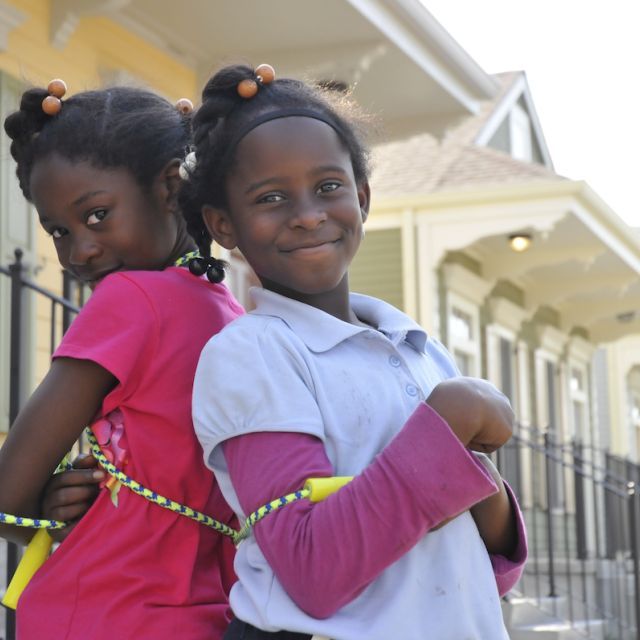 Two girls with jump rope standing in front of homes