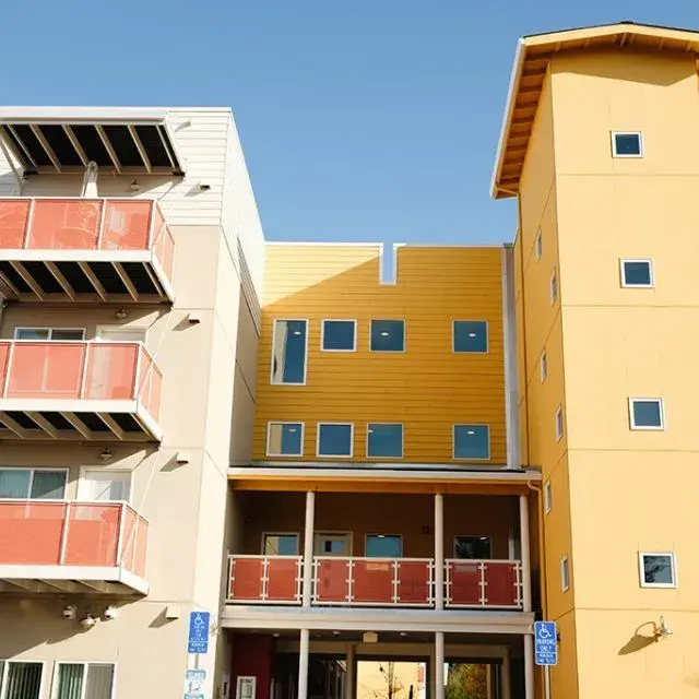 A close-up view of the City Center Apartments, a yellow and cream building with brick-colored balconies.